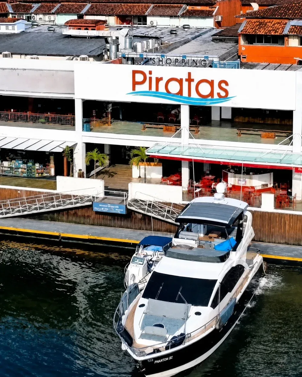 Fachada do Shopping Piratas com acesso náutico e embarcação atracada